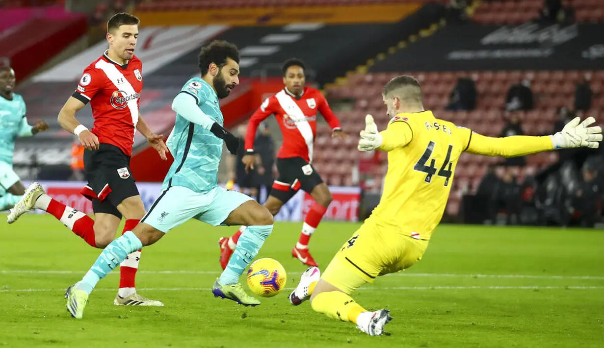 Kiper Southampton Fraser Forster (kanan) memblok tembakan ke gawang dari pemin Liverpool Mohamed Salah pada pertandingan Liga Inggris di St Mary's Stadium, Southampton, Inggris, Senin (4/1/2021). Southampton menang 1-0 atas Liverpool. (AP Photo/Michael Steele,Pool)