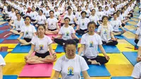 Sejumlah orang melakukan gerakan yoga di Zhenjiang, Provinsi Jiangsu, Cina, (20/6). Sejumlah negara di dunia sedang merayakan Hari Yoga Dunia yang jatuh pada tanggal 21 Juni. (REUTERS/Stringer)