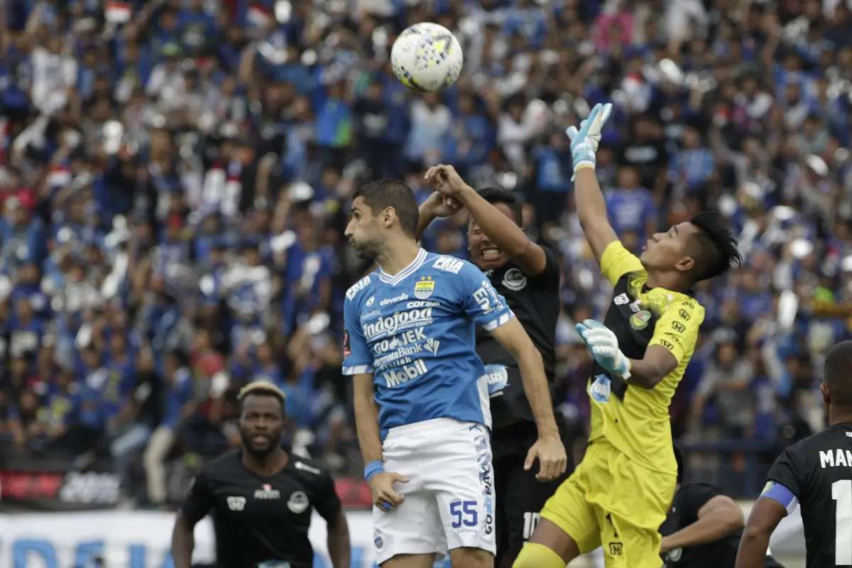 Gelandang Persib Bandung, Srdan Lopicic, duel udara dengan kiper TIRA Persikabo, Angga Saputro, pada laga Piala Presiden 2019. (Bola.com/Yoppy Renato)