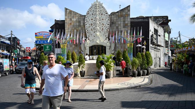 Turis asing mengunjungi Monumen Bom Bali di Kuta, dekat Denpasar pada Sabtu (12/10/2019). MeMperingati 18 tahun peristiwa bom Bali yang terjadi pada 12 Oktober 2002, wisatawan dan kerabat korban mengunjungi tugu peringatan untuk berdoa dan tabur bunga. (SONNY TUMBELAKA / AFP)
