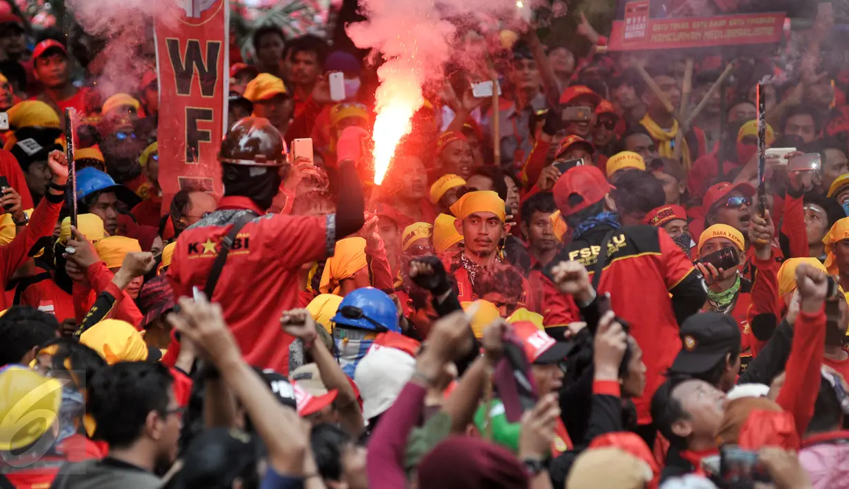 Buruh menyalakan flare saat aksi Hari Buruh di Jalan Medan Merdeka, Jakarta, Senin (5/1). Minta diperbolehkan mendekat ke Istana Negara, buruh menyalakan kembang api dan flare. (Liputan6.com/Yoppy Renato)