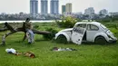 Seorang gadis memeriksa ponselnya sambil duduk di lapangan terbuka di sepanjang tepi sungai Merah di Hanoi (13/0/2020). (AFP/Manan Vatsyayana)