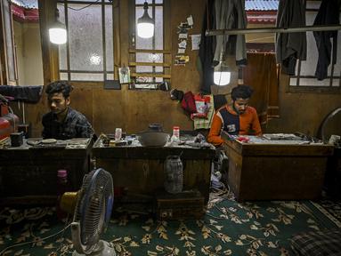 Perajin membuat ornamen di bengkel perhiasan emas di Srinagar (24/6/2021). Srinagar merupakan menjadi salah satu pusat industri kerajinan perhiasan emas. (AFP/Tauseef Mustafa)