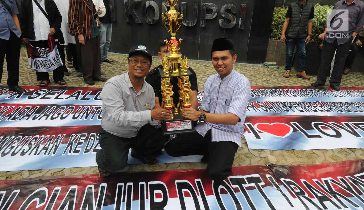 Tokoh masyarakat Kabupaten Cianjur berpose dengan sebuah piala di Gedung KPK, Jakarta, Selasa (18/12). Piala itu diberikan sebagai apresiasi atas operasi tangkap tangan (OTT) Bupati Cianjur Irvan Rivano Muchtar oleh KPK. (Merdeka.com/Dwi Narwoko)
