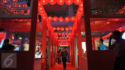 Pengunjung melintas di antara ratusan lampion yang terpasang di Mall Taman Anggrek, Jakarta, Jumat (20/1). Keberadaan lampion tersebut menjadi daya tarik pengunjung untuk sekedar melihat-lihat. (Liputan6.com/Angga Yuniar)