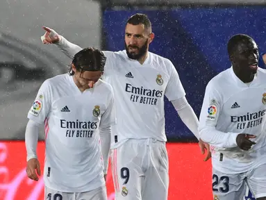 Striker Real Madrid, Karim Benzema (tengah) melakukan selebrasi usai mencetak gol pertama timnya ke gawang Getafe dalam laga lanjutan Liga Spanyol 2020/21 pekan ke-22 di Alfredo di Stefano Stadium, Selasa (9/2/2021). Real Madrid menang 2-0 atas Getafe. (AFP/Gabriel Bouys)