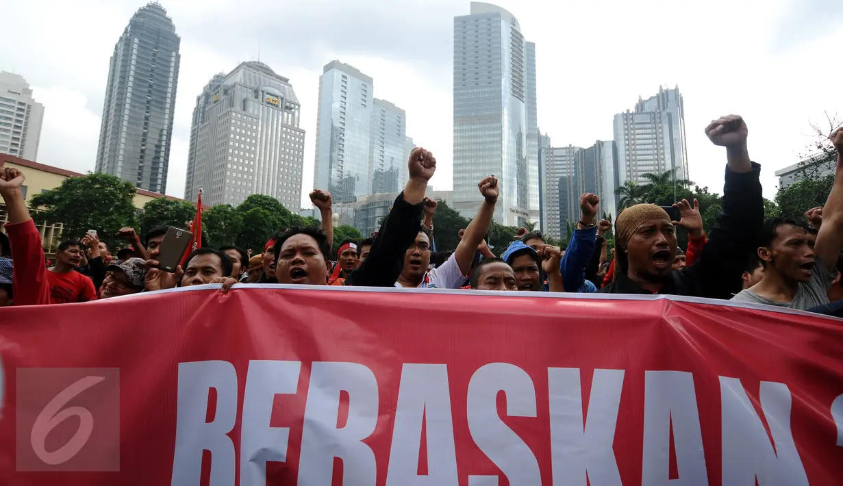 Ratusan buruh mengangkat tangan saat aksi di lapangan DitSabhara Polda Metro Jaya, Jakarta, Rabu (17/2/2016). Dalam aksinya, mereka meminta pencabutan status tersangka pada 26 orang buruh aktivis. (Liputan6.com/Helmi Fithriansyah)