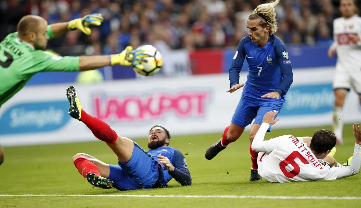 Kiper Belarusia, Sergei Chernik menghalau bola dari kejaran pemain Prancis, Olivier Giroud danAntoine Griezmann pada kualifikasi Piala Dunia 2018 grup A di Stade de France stadium, Saint-Denis (10/10/2017). Prancis menang 2-1. (AP/Christophe Ena)