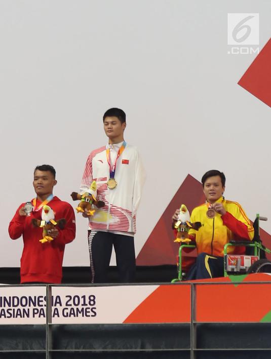 Atlet Indonesia Aris Wibawa saat penyerahan mendali dalam babak final putra 100 meter gaya dada SB7 para renang Asian Para Games 2018 di Aquatic Center, GBK, Jakarta, Senin (8/10). Aris berhasil meraih perak dalam kelas tersebut. (Merdeka.com/Imam Buhori)