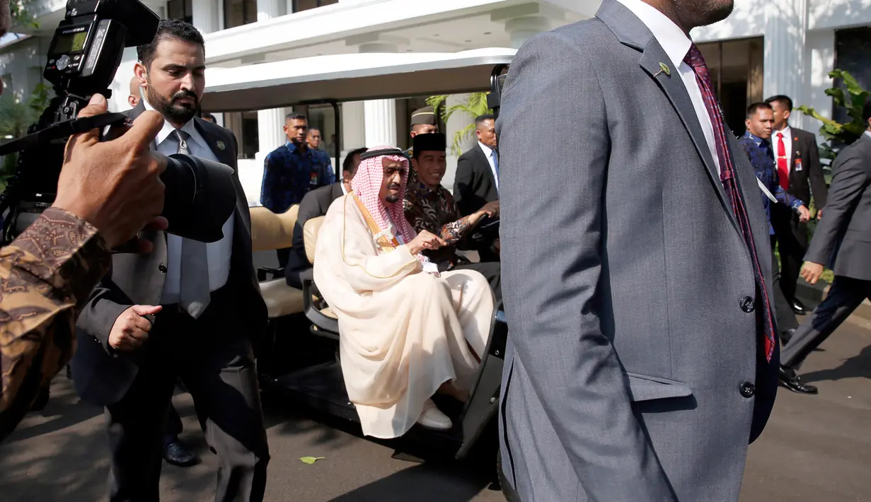 Sejumlah pengawal Raja Salman terlihat menjaga ketat mobil yang dikemudikan Jokowi saat keliling halaman Istana Merdeka, Jakarta, Kamis (2/3). (AFP Photo/ Pool/ ADI WEDA)