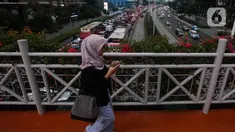 Warga melintasi Jembatan Penyeberangan Orang (JPO) di Jakarta, Kamis (31/8/2023). (Liputan6.com/Johan Tallo)