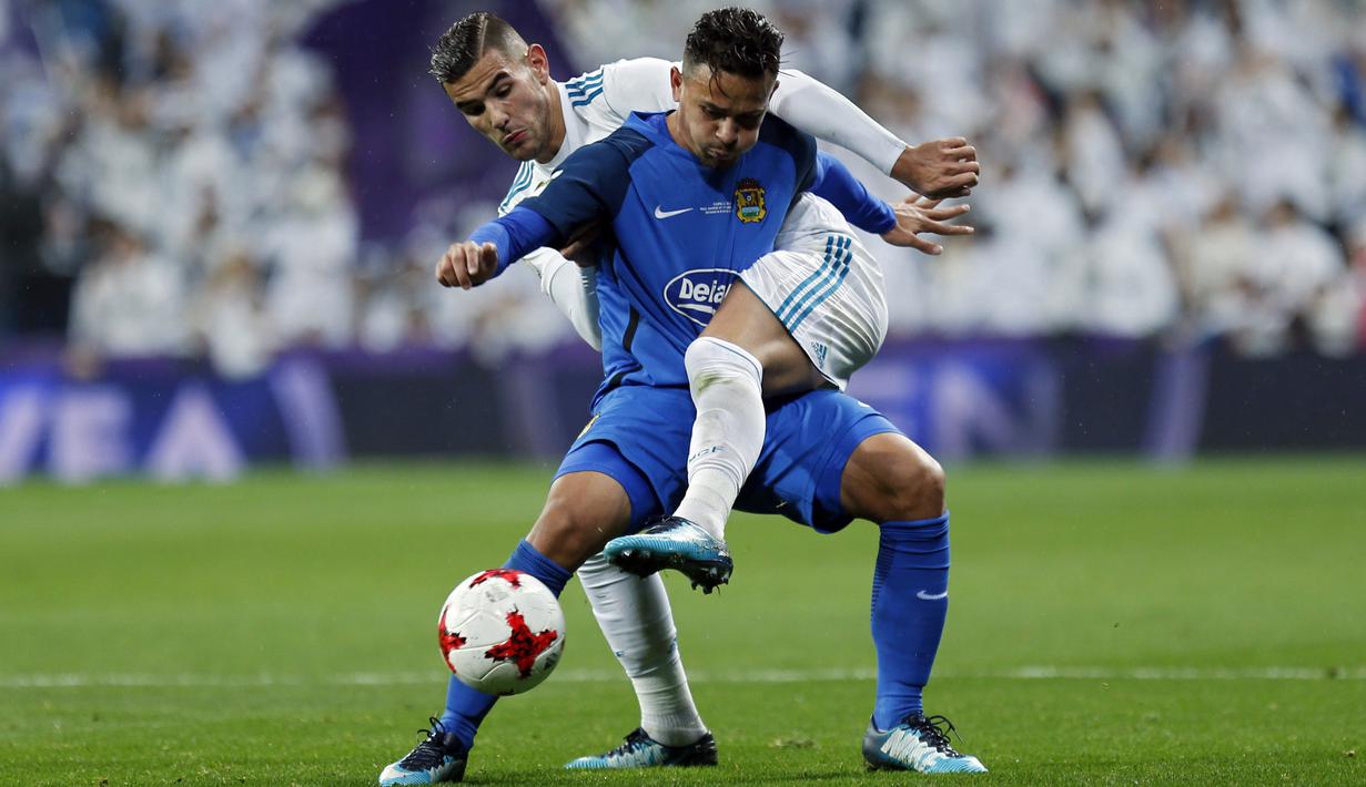 Pemain Real Madrid, Theo Hernandez (belakang) berebut bola dengan pemain Fuenlabrada, Hugo Fraile pada laga Copa del Rey babak 32 besar di Santiago Bernabeu stadium, Madrid, (28/11/2017). Real Madrid bermain imbang 2-2. (AP/Francisco Seco)