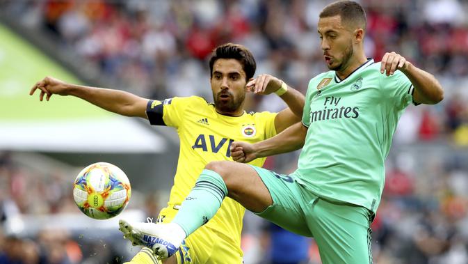 Gelandang Real Madrid, Eden Hazard berebut bola dengan pemain Fenerbache, Alper Potuk selama pertandingan Audi Cup 2019 di stadion Allianz Arena di Munich, Jerman (31/7/2019). Madrid menang atas Fenerbache dengan skor 5-3. (AP Photo/Matthias Schrader)