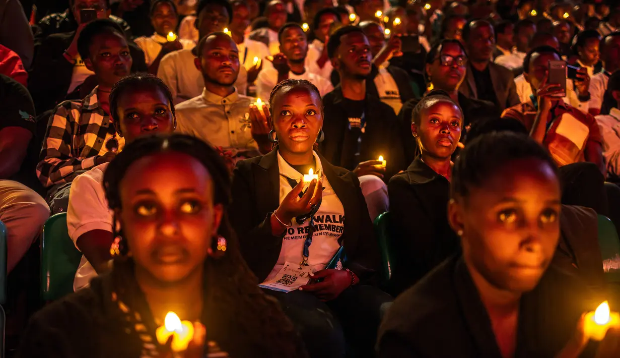 Para pemuda Rwanda memegang lilin saat mengambil bagian dalam acara mengheningkan cipta memperingati 30 tahun genosida Rwanda tahun 1994 di BK Arena, Kigali, 7 April 2024. (LUIS TATO/AFP)
