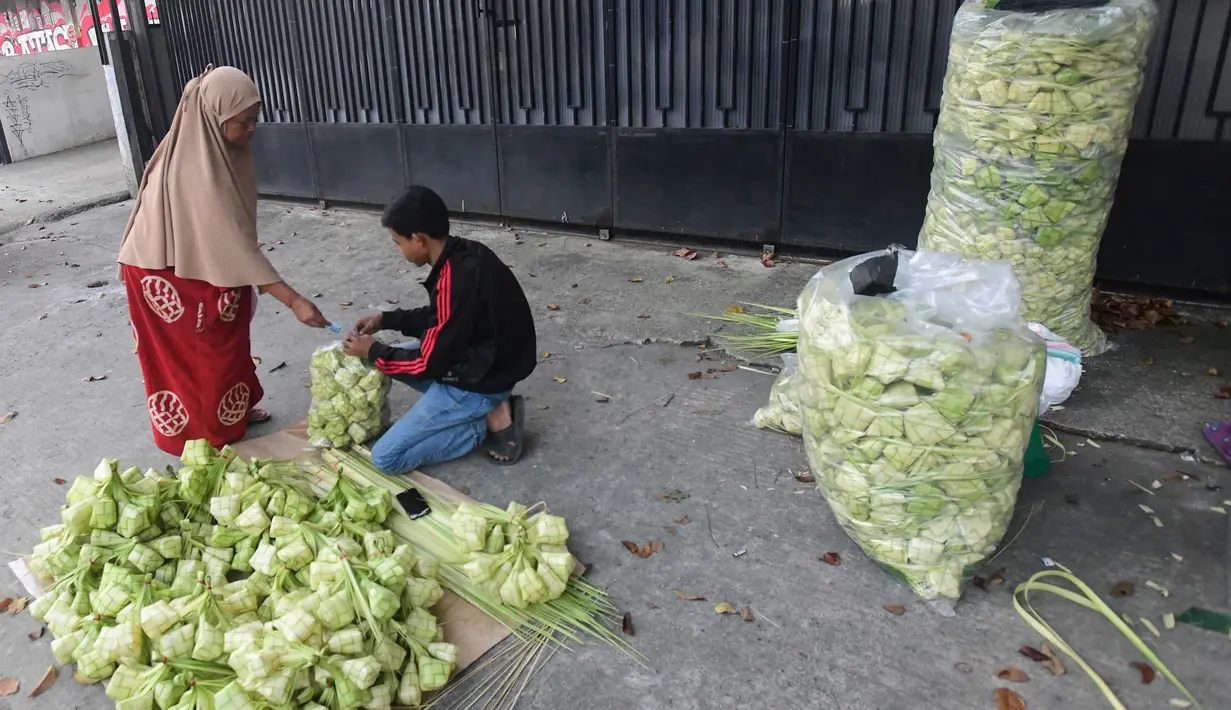 Peningkatan produksi ini menjadi bagian kebutuhan bahan pelengkap hidangan khas lebaran. Tampak dalam foto, pedagang menyelesaikan produksi kulit ketupat lebaran di Pasar Pondok Labu, Jakarta, Rabu (18/3/2026). (merdeka.com/Arie Basuki)