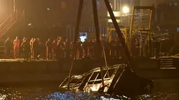 Sebuah crane mengevakuasi bus setelah jatuh dari jembatan ke Sungai Yangtze di Chongqing barat daya China (1/11). Bus berisikan 15 orang jatuh ke Sungai Yangtze, China pada Minggu (28/10). (AFP Photo/Str)