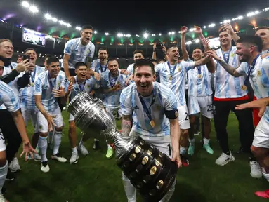Penyerang  Argentina, Lionel Messi merayakan trofi  Copa America 2021 bersama rekannya usai mengalahkan Brasil 1-0 dalam pertandingan final di stadion Maracana, Brasil, Minggu (11/7/2021). Inilah kali pertamanya  Messi mempersembahkan trofi juara bagi Albiceleste. (AP Photo/Bruna Prado)