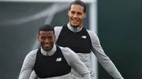 Keceriaan dua pemain asal Belanda Virgil van Dijk (kanan) dan Georginio Wijnaldum saat sesi latihan Liverpool di Melwood Training Ground, Liverpool, (3/4/2018). Liverpool akan menjamu Manchester City pada leg pertama Liga Champions. (AFP/Paul Ellis)