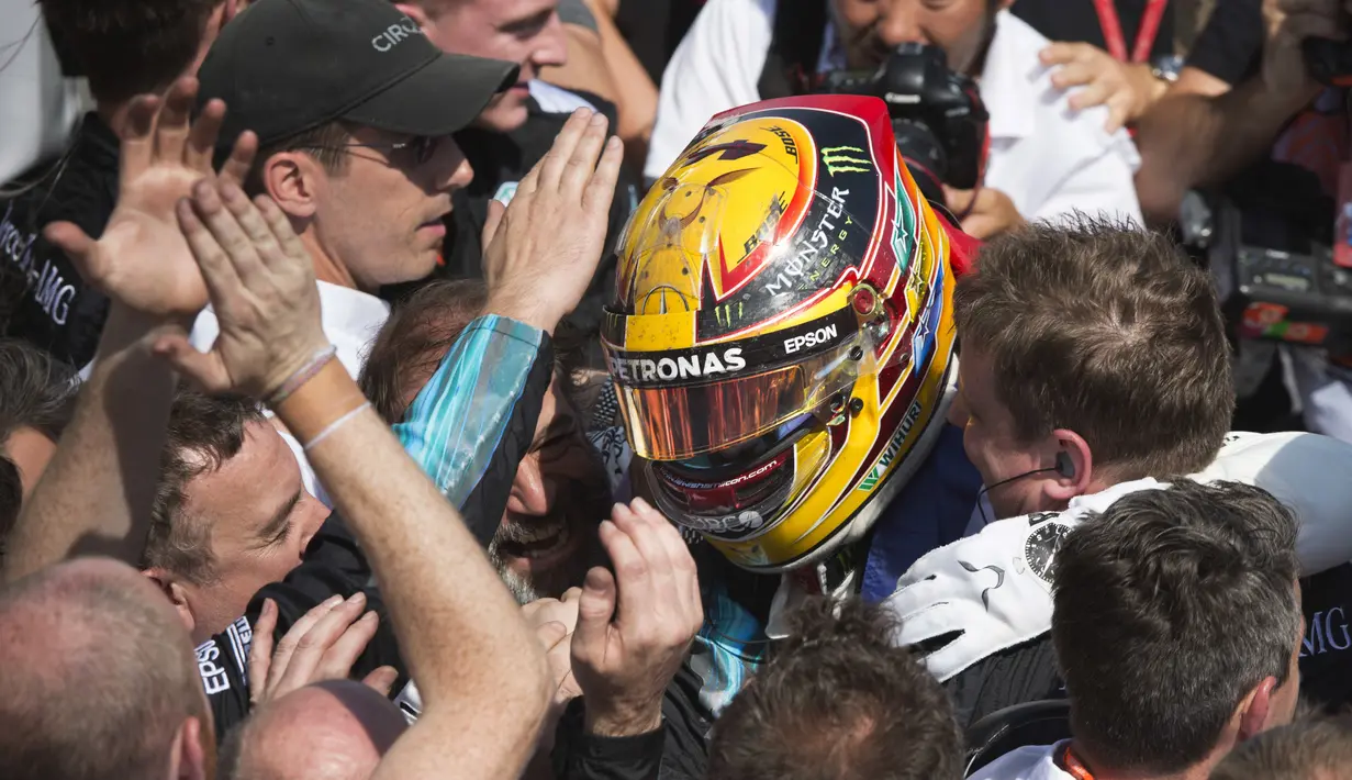 Pebalap Mercedes, Lewis Hamilton dikerubutin awak timnya usai menjuarai ajang Formula One Canadian Grand Prix di Montreal, Canada, (11/6/2017).  (Tom Boland/The Canadian Press via AP)