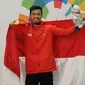 Pesilat Indonesia Abdul Malik mengangkat bendera Merah Putih usai menaklukkan Muhammad Faizul M Nasir asal Malaysia di final Kelas B Putra Asian Games 2018 di Jakarta, Senin (27/8). Abdul menang dan mendapatkan medali emas. (Merdeka.com/Arie Basuki)