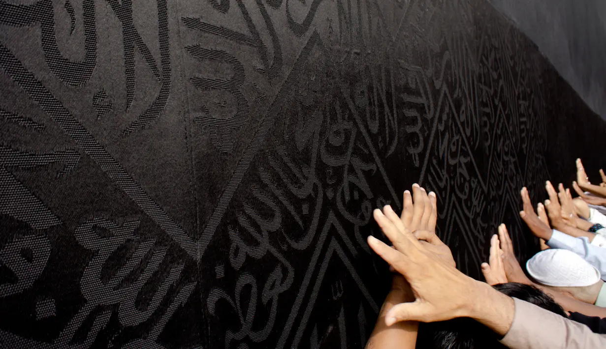 Umat muslim memanjatkan doa dengan menyentuh dinding Kabah selama menjalani ibadah umrah di Masjidil Haram, Mekkah, 4 Mei 2018. Banyak umat muslim yang menyambut bulan Ramadan dengan menjalankan ibadah umrah ke tanah suci. (AP Photo/Amr Nabil)