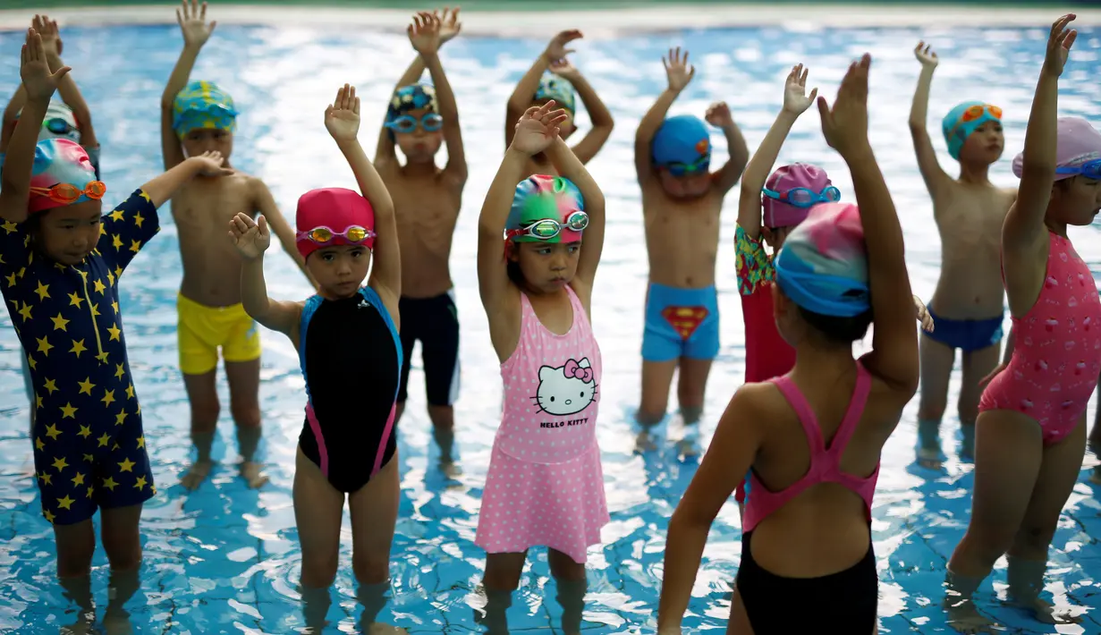 Anak-anak melakukan pemanasan sebelum latihan berenang di sekolah olahraga Hangzhou Chen Jinglun Natatorium, di Hangzhou, provinsi Zhejiang, China, (10/8). (REUTERS/Aly Song)