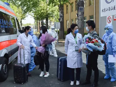 Staf medis mengucapkan selamat jalan ke pasien sembuh COVID-19 di Beijing, China (28/4/2020). Rumah Sakit Xiaotangshan yang digunakan untuk mengarantina pasien SARS di Beijing, telah memulangkan semua pasien COVID-19 Selasa (28/4) dan dijadwalkan berhenti beroperasi Rabu (29/4). (Xinhua/Peng Ziyang)
