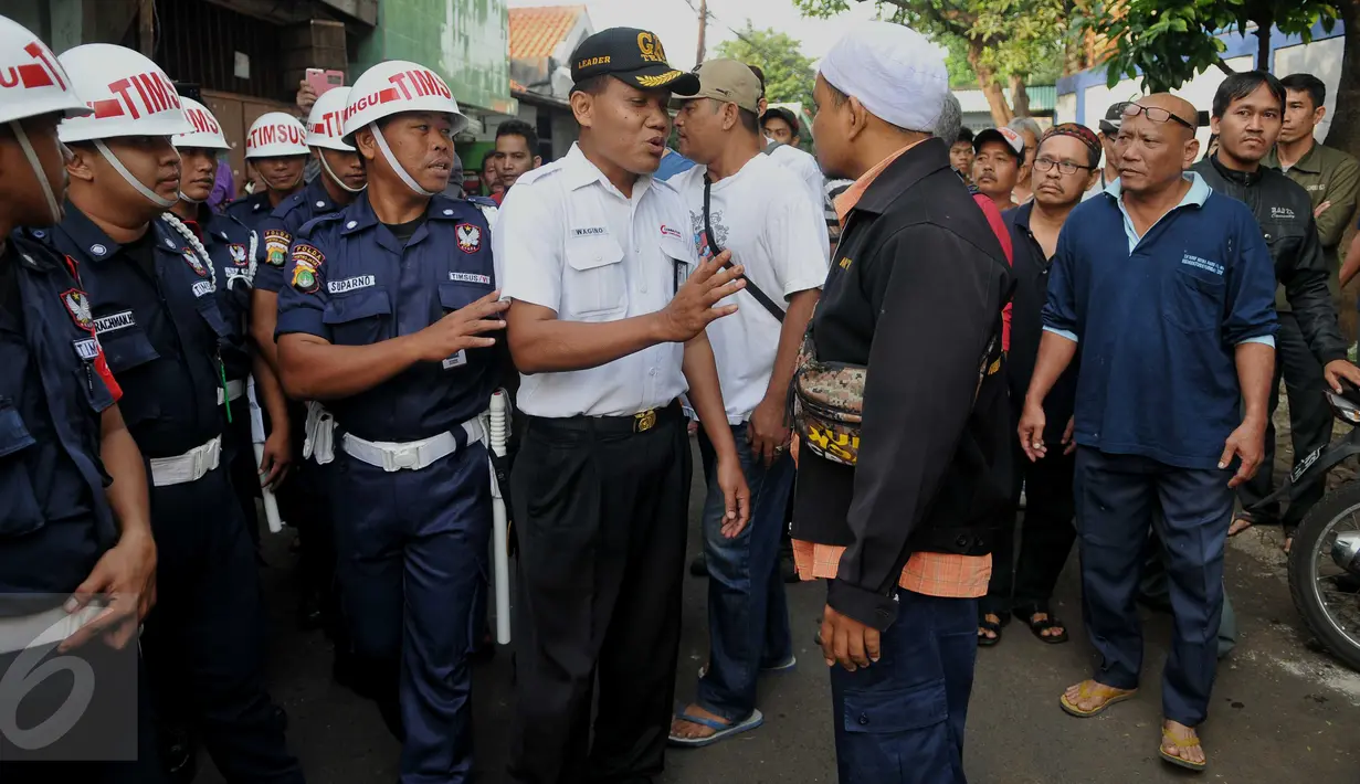 Petugas melakukan mediasi dengan warga saat akan melakukan pengosongan rumah aset kepemilikan PT KAI di Kelurahan Manggarai, Jakarta, Selasa (19/7). Warga menolak terhadap pengosongan rumah yang dilakukan oleh PT KAI. (Liputan6.com/Gempur M Surya)
