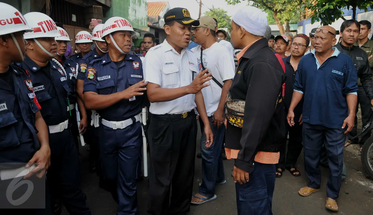 Petugas melakukan mediasi dengan warga saat akan melakukan pengosongan rumah aset kepemilikan PT KAI di Kelurahan Manggarai, Jakarta, Selasa (19/7). Warga menolak terhadap pengosongan rumah yang dilakukan oleh PT KAI. (Liputan6.com/Gempur M Surya)