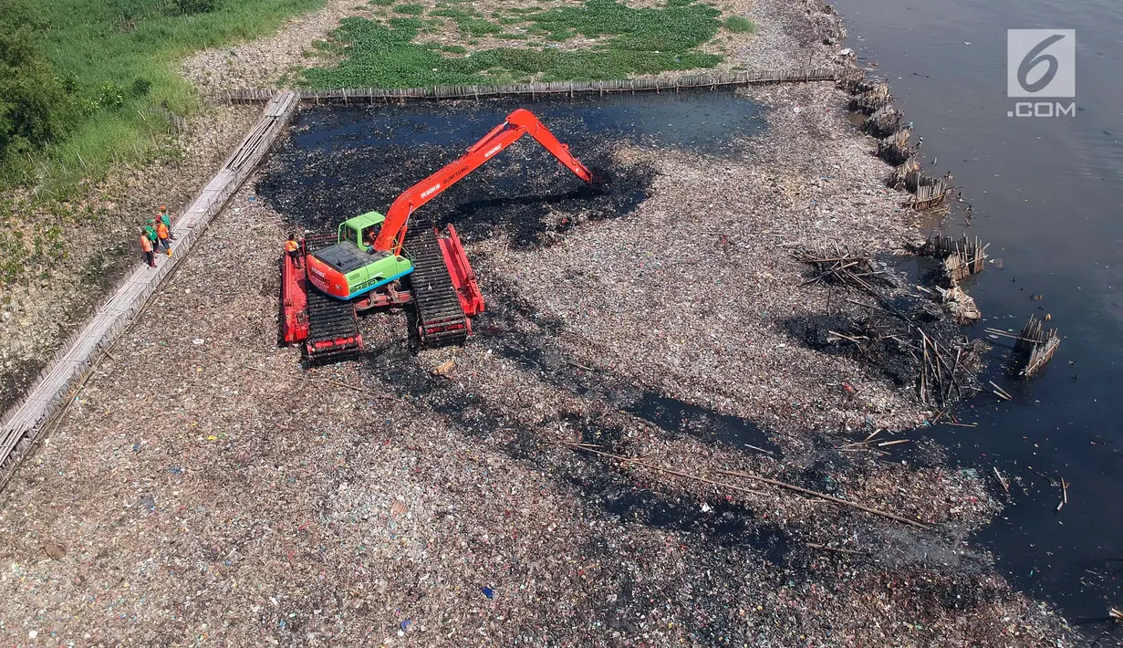 Eskavator melakukan pengerukan sampah di kawasan Hutan Mangrove Ecomarine Muara Angke, Jakarta Utara, Minggu (18/3). Sampah didominasi sampah plastik seperti botol air kemasan, bungkus deterjen, hingga kemasan makanan ringan. (Liputan6.com/Arya Manggala)