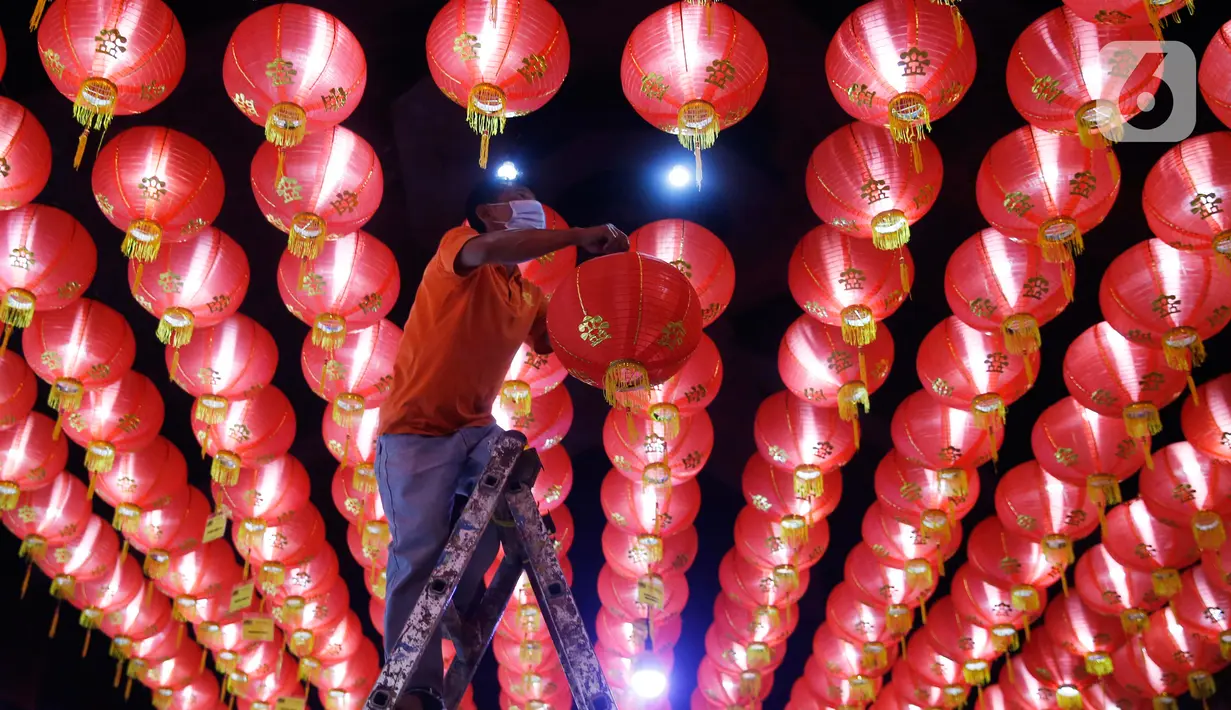 Seorang pekerja memasang lampion pemberian umat di Klenteng Boen San Bio, Tangerang, Kamis (28/1/2021). Sebanyak 800  lampion dipasang untuk mempercantik Klenteng jelang perayaan Tahun Baru Imlek. (Liputan6.com/Angga Yuniar)