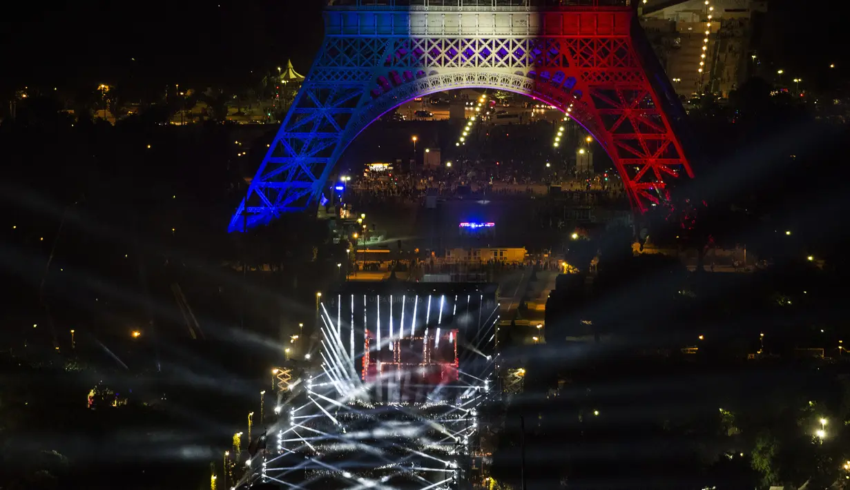 Suasana kemeriahan acara Champs de Mars yang digelar untuk menyambut Piala Eropa 2016 di Paris fan zone, belakang Menara Eiffel, Prancis, Jumat (10/6/2016). (AFP/Geoffroy Van Der Hasselt)