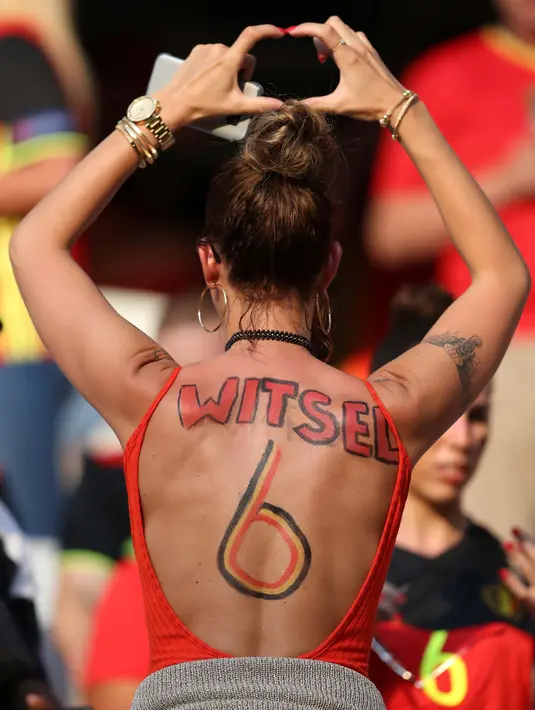 Fans seksi Belgia mencoret punggungnya dengan nomor pemain Belgia saat laga grup E Euro Cup 2016 di Stadion Allianz Riviera, Nice, Kamis (23/6/2016) dini hari WIB. (AFP/Valery Hache)
