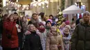 Anak-anak mendengarkan pemandu saat bertamasya di toserba GUM yang didekorasi untuk perayaan Tahun Baru dan Natal di dekat Lapangan Merah di Moskow, Rusia, pada Selasa, 26 Desember 2023. (AP Photo/Alexander Zemlianichenko)