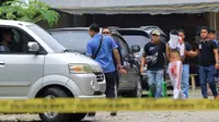 Petugas polisi mengawal pelaku teror bom bunuh diri di Gereja Santo Yosep Medan, Sumut, Minggu (28/8). Pelaku berhasil diamankan, lantaran bom yang dibawa di dalam ransel dan hendak diledakkan saat Misa, justru gagal meledak dan melukai pelaku. (AFP/STR)