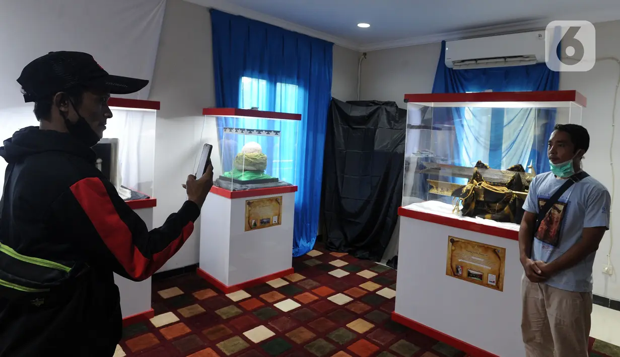 Pengunjung berpose dengan benda peninggalan Nabi Muhammad SAW dalam pameran artefak asli Rasulullah di Masjid Jami At-Taqwa, Sukamaju, Depok, Jawa Barat, Selasa (29/12/2020). Pameran ini dalam rangka meningkatkan kecintaan kepada Nabi Muhammad SAW. (merdeka.com/Arie Basuki)