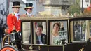 Putri Eugenie dan Jack Brooksbank menaiki kereta kencana usai melangsungkan pernikahan di Kapel St. George, Windsor Castle, London, Inggris,  Jumat (12/10). Putri Eugenie merupakan anak bungsu Pangeran Andrew dan Sarah Ferguson. (AP Photo/Rui Vieira)