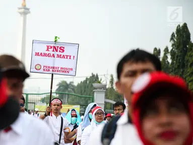 Seorang massa membawa poster dalam aksi damai di depan Istana Negara, Jakarta, Rabu (19/7). Mereka mendesak agar para pegawai non PNS yang telah mengabdi pada garda depan pelayanan publik, bisa diangkat menjadi PNS. (Liputan6.com/Faizal Fanani)