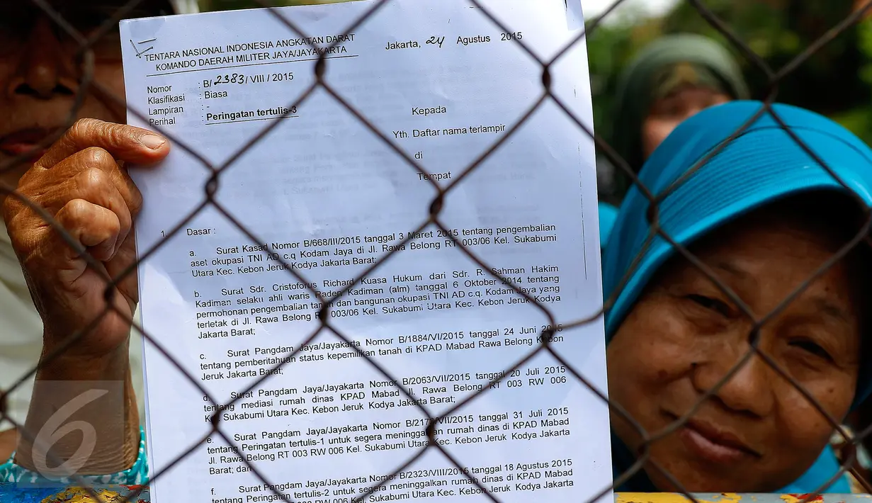 Seorang ibu menunjukan SP 3 yang dikeluarkan oleh Kodam Jaya TNI saat aksi damai menolak pengosongan rumah mereka di Perumahan Perwira Mabad, Rawabelong, Jakarta, Senin (7/9/2015). (Liputan6.com/Yoppy Renato)