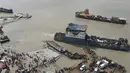 Foto udara yang diambil pada 27 Juni 2021 ini memperlihatkan penumpang naik kapal feri jelang pengetatan lockdown, Munshiganj, Bangladesh. Kasus infeksi COVID-19 di Bangladesh sempat menurun pada Mei tetapi mulai meningkat lagi bulan ini. (Munir Uz zaman/AFP)