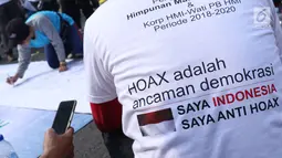 Salah satu pengurus PB HMI melihat warga yang menandatangani spanduk dukungan anti hoax di kawasan Bundaran Hotel Indonesia, Jakarta, Minggu (18/11). PB HMI mensosialisasikan Hoax sebagai ancaman demokrasi di Indonesia. (Liputan6.com/Helmi Fithriansyah)
