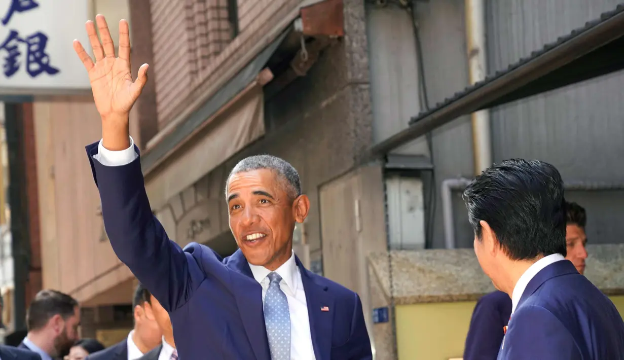 Presiden AS ke-44 Barack Obama menyapa awak media saat tiba di restoran sushi di kawasan Ginza, Tokyo, Jepang, (25/3). Obama akan menghadiri sebuah forum internasional yang diselenggarakan oleh organisasi swasta. (AP Photo / Shizuo Kambayashi, Pool)