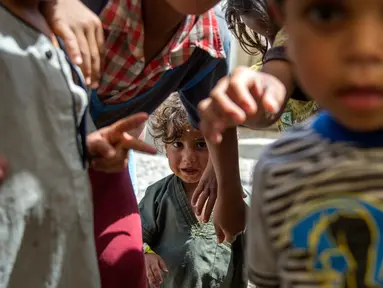 Anak-anak Irak berpose di sebuah kamp di Hammam al-Alil, Irak, Rabu (3/5). Pengungsi di kamp ini adalah warga Irak yang menyelamatkan diri dari ISIS di Mosul Barat. (AFP PHOTO / FADEL SENNA)