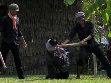 Sejumlah aktor memperagakan pembunuhan massal yang dilakukan prajurit Khmer Merah saat berkuasa di  Phnom Penh, Kamboja, (20/5). Perayaan ini dipusatkan di depan Choeung Ek, museum Killing Fields di pinggiran Phnom Penh. (AFP PHOTO/TANG CHHIN SOTHY)