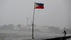 Bendera Filipina berkibar di dekat seorang warga yang memancing ditengah cuaca buruk akibat Topan Nepartak yang menerpa di Manila Bay, Filipina, Jumat (8/7). (REUTERS/Erik De Castro)