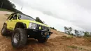 Peserta perjalanan menuju Ujung Kulon memanfaatkan sebuah gundukan tanah untuk beraksi dengan Jeep Cherokee-nya, Jumat (15/5/14), (Liputan6.com/Faizal Fanani)