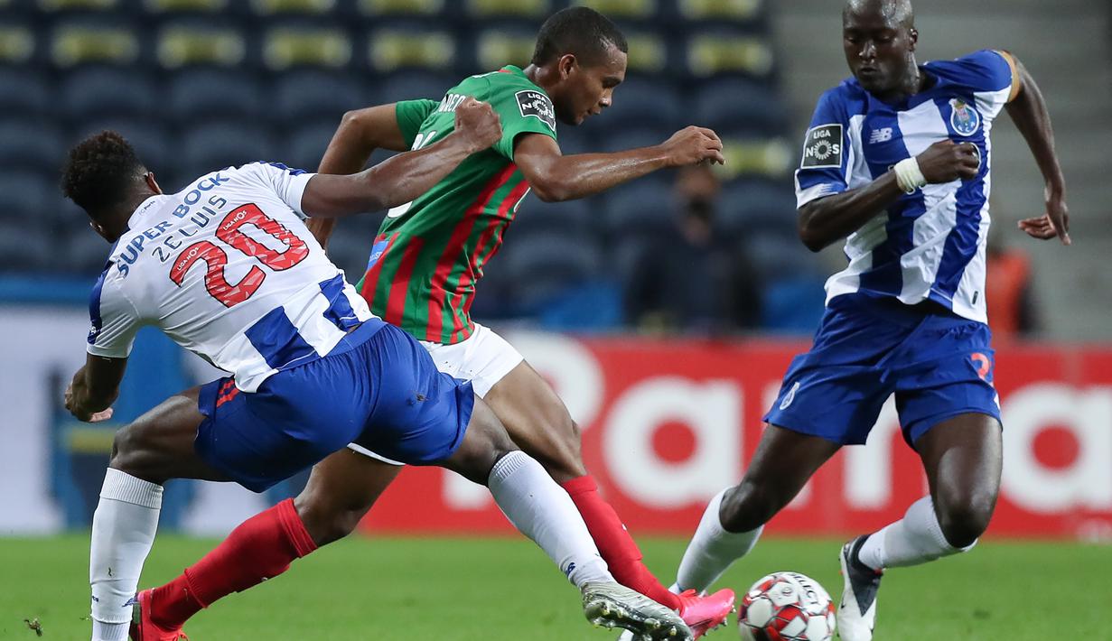 Striker FC Porto, Ze Luis, berebut bola dengan gelandang Maritimo, Diego Moreno, pada laga lanjutan Liga Portugal di Dragao Stadium, Porto, Kamis (10/6/2020) waktu setempat. Porto menang tipis 1-0 atas Maritimo. (AFP/Jose Coelho/Pool)