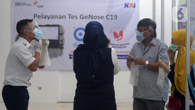 Petugas mengajari calon penumpang untuk tes COVID-19 dengan GeNose C19 di Stasiun Pasar Senen, Jakarta, Selasa (23/2/2021). Hasil tes tersebut kemudian menjadi dokumen syarat perjalanan para penumpang kereta. (merdeka.com/Imam Buhori)