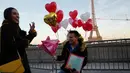 Gerson asal Honduras melamar pasangannya Andry pada Hari Valentine ketika mereka berdiri di Trocadero Plaza dekat Menara Eiffel di Paris, Prancis (14/2). (AFP Photo/Ludovic Marin)