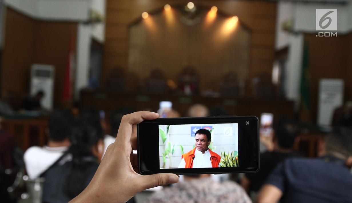 Foto Gubernur Aceh nonaktif Irwandi Yusuf terpampang pada layar handphone saat sidang praperadilan di PN Jakarta Selatan, Rabu (24/10). Hakim tunggal Riyadi Sunindyo menolak permohonan praperadilan Irwandi Yusuf. (Liputan6.com/Herman Zakharia)